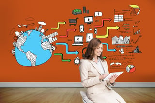 Composite image of pleased businesswoman using a tablet pc sitting on chair in front of orange wall showing economic illustrations.jpeg