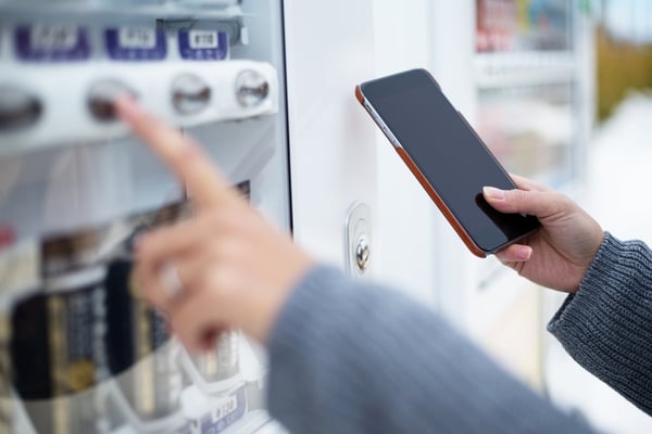 Woman use of soft drink vending system paying by cellphone