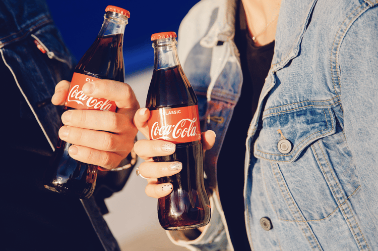 people drinking coca cola from glass bottles